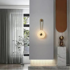 Modern-black-and-gold-wall-light-above-side-table

